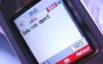 Ecrire un SMS : deux jeunes filles donnent des cours du soir aux grands-parents